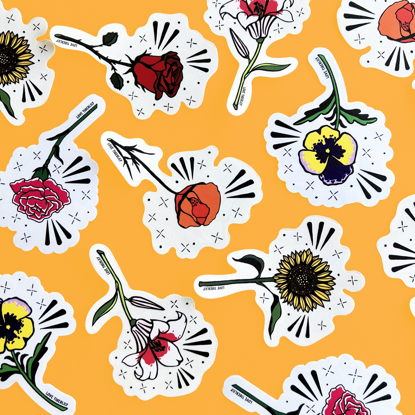 Photo showcasing multiple floral suncatcher stickers (Poppy, Rose, Lily, Pansy, Carnation and Sunflower) over a yellow background.