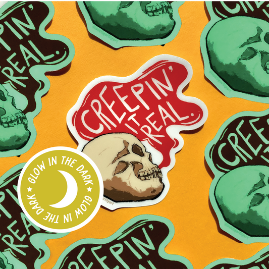 Multiple of the Glow in the Dark Creepin It Real sticker of an illustrated skull saying “Creepin It Real”
