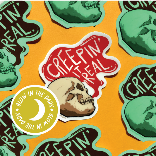 Multiple of the Glow in the Dark Creepin It Real sticker of an illustrated skull saying “Creepin It Real” 
