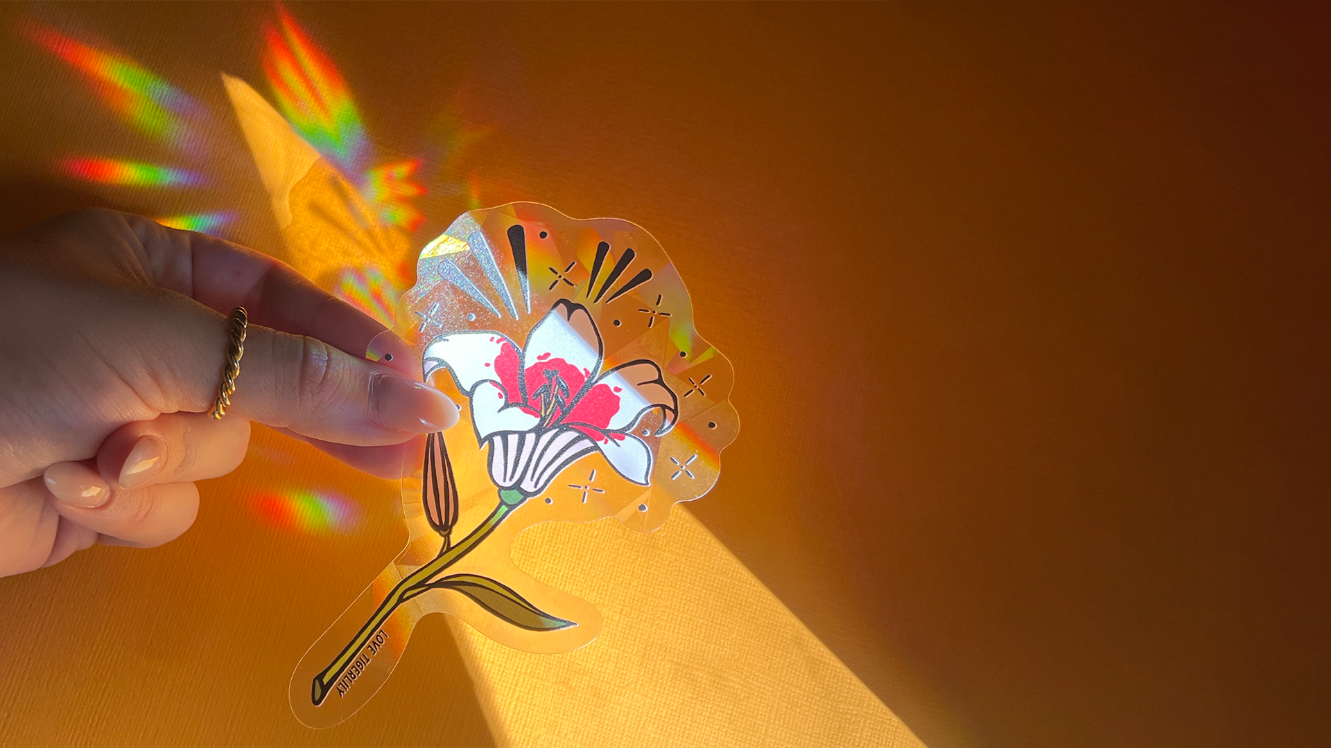 Stargazer Lily Suncatcher Decal Creating Rainbows on a Yellow Background