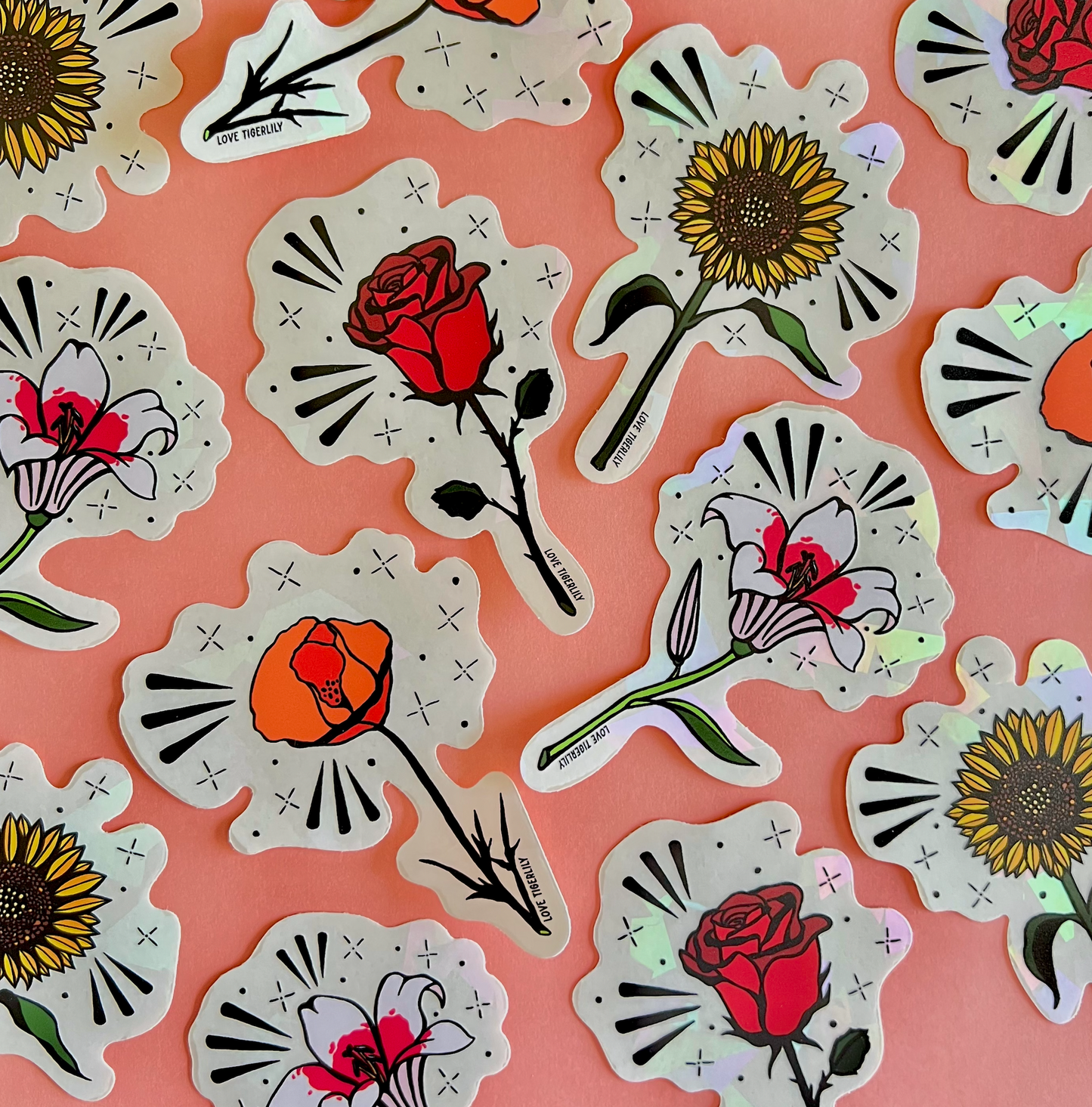 Photo showcasing multiple floral suncatcher stickers (Poppy, Rose, Lily, and Sunflower) over a pink background.