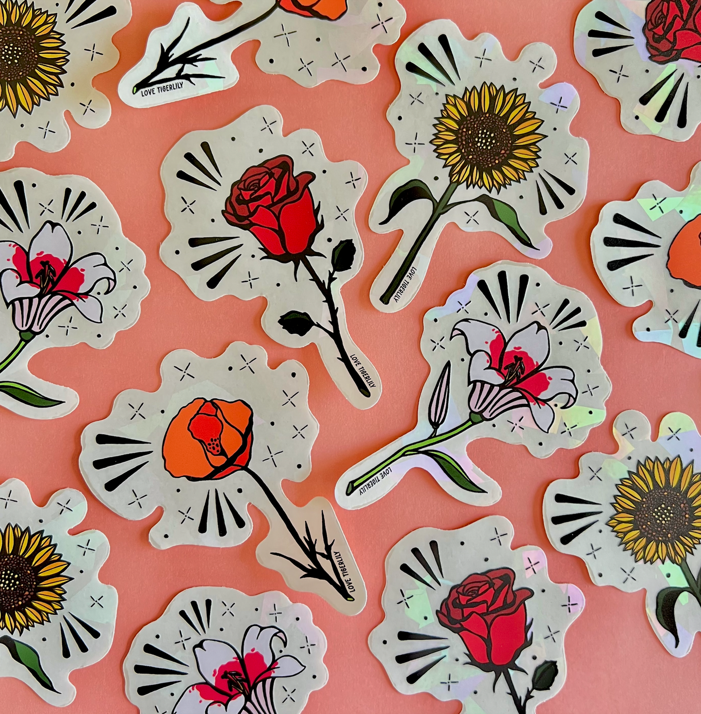 Photo showcasing multiple floral suncatcher stickers (Poppy, Rose, Lily, and Sunflower) over a pink background.